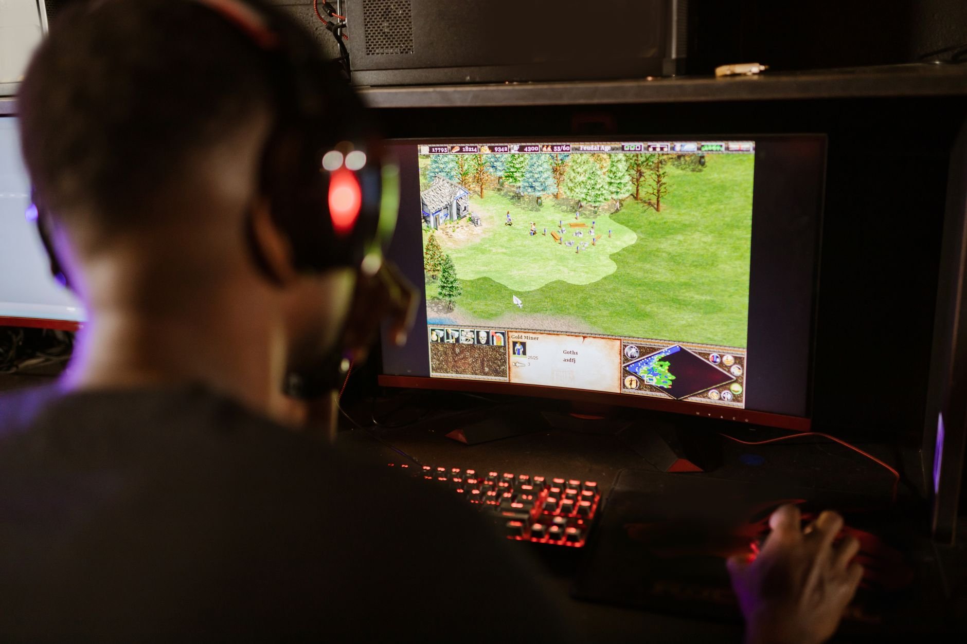 A gamer intensely playing a strategy game on a high-resolution monitor — smooth, focused gameplay